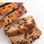 A whole loaf of sliced vegan banana bread on a marble background.