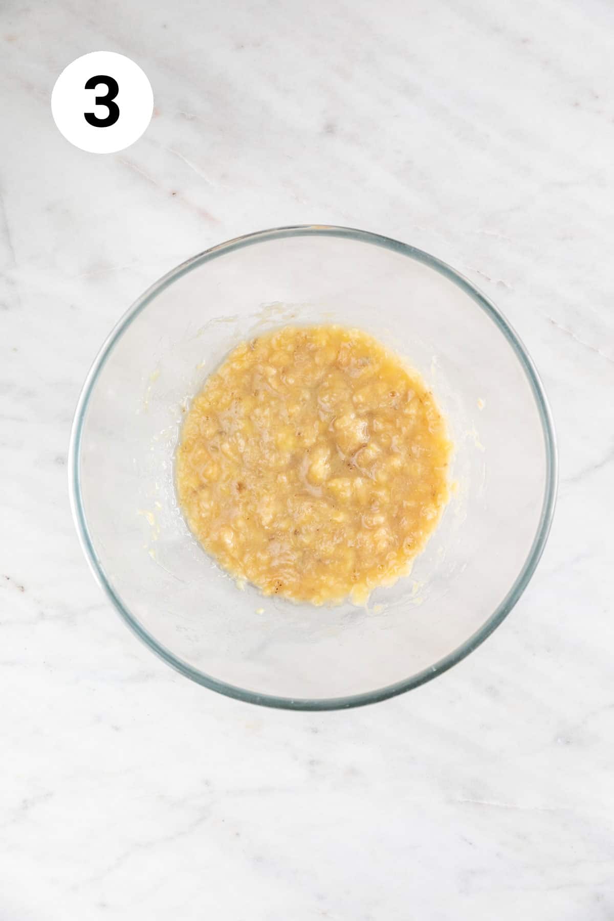 Mashed bananas in a large mixing bowl.