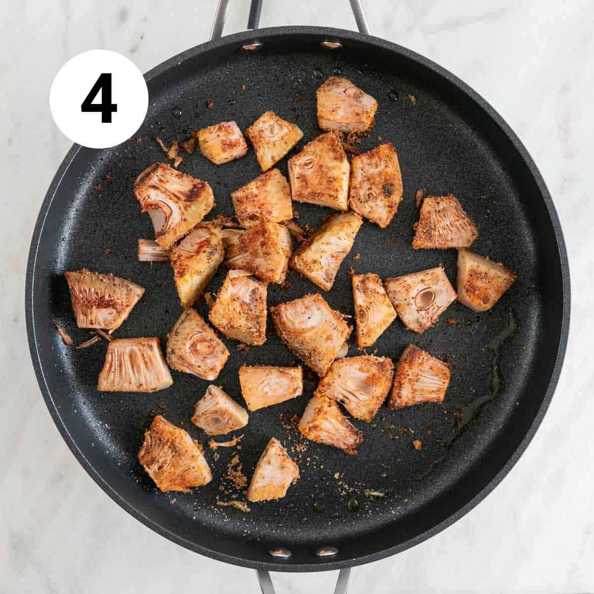 Sautéed jackfruit in a skillet with spices.