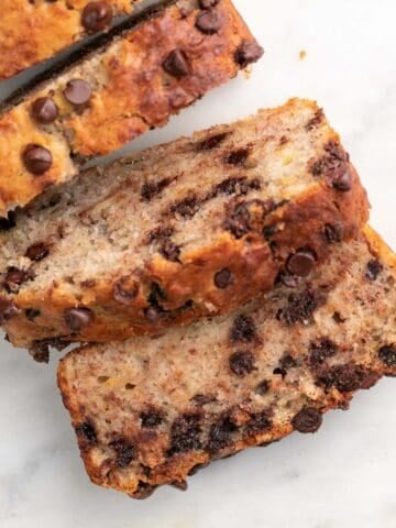 Sliced vegan banana bread on marble.