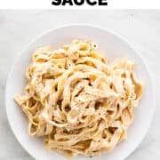 Vegan cashew alfredo pasta dish garnished with freshly ground black pepper.