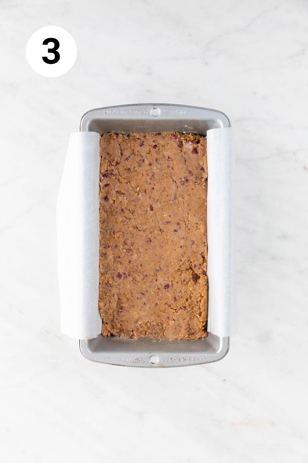 Loaf pan with a vegan meatloaf before baking and before adding the glaze.