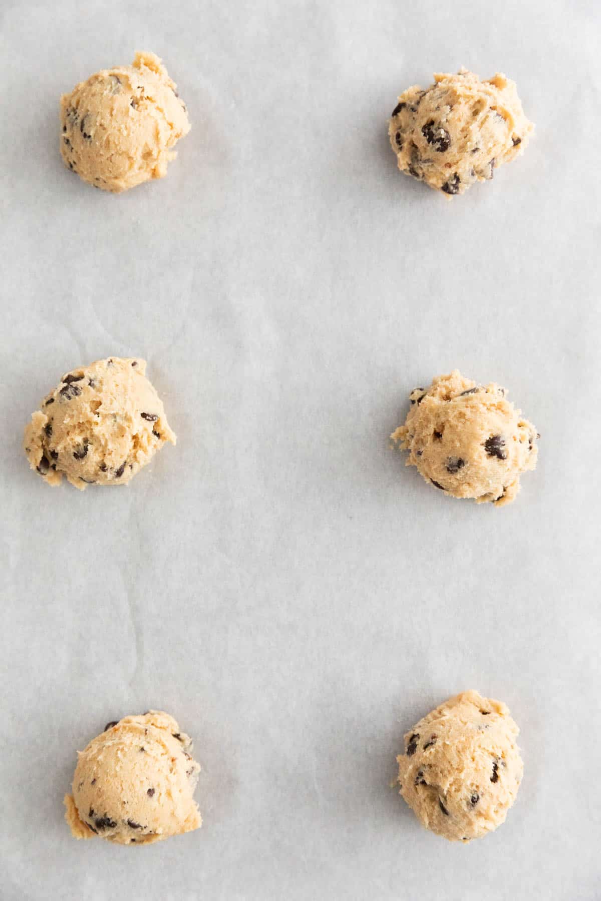 Cookie balls onto a lined baking sheet.
