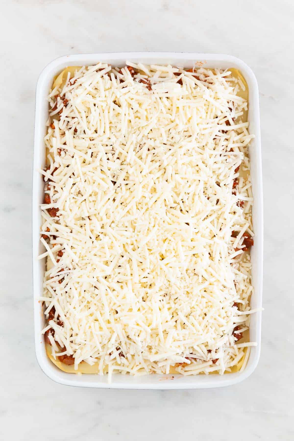 The baked vegan lasagna with the last layer of vegan mozzarella uncooked.
