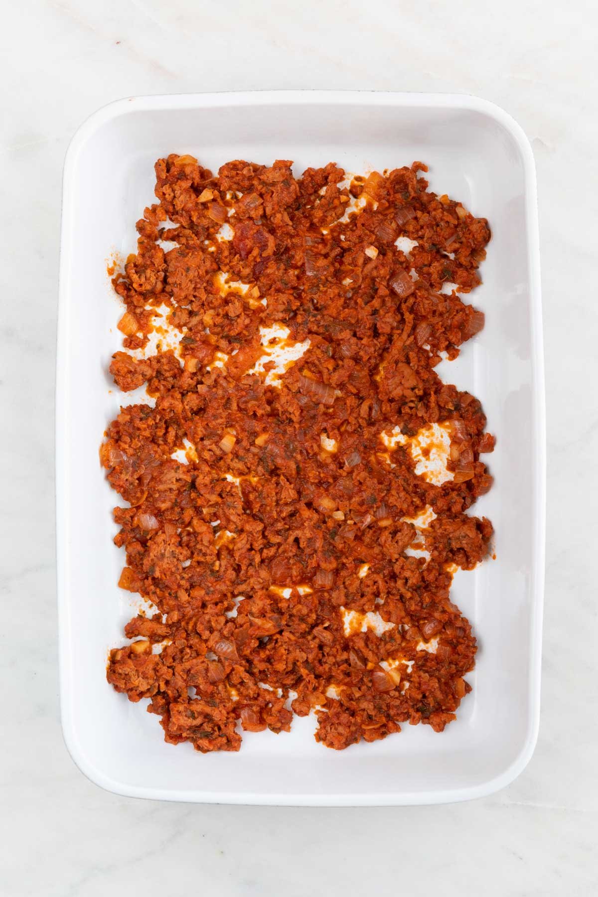 A casserole dish with some vegan meat sauce.