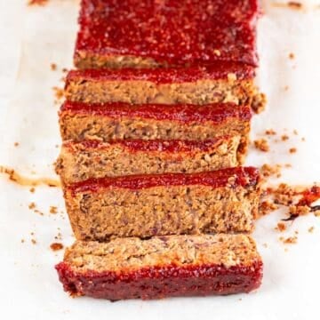 Sliced vegan meatloaf against a white backdrop.