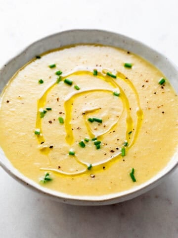 Vegan potato leek soup served in a bowl with toppings.