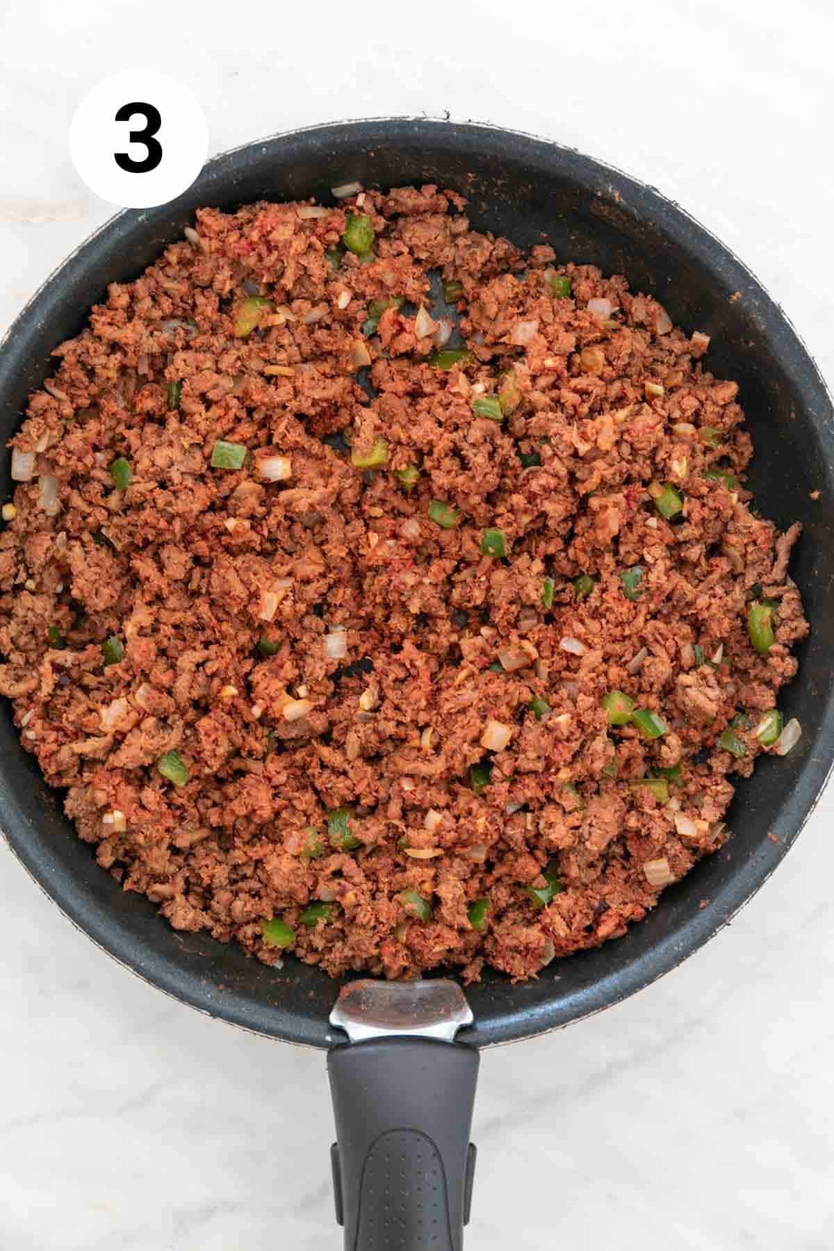 Mixture of vegan ground beef, veggies, and tomato paste in a skillet.