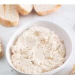 A bowl with vegan tofu ricotta cheese and some bread slices around.
