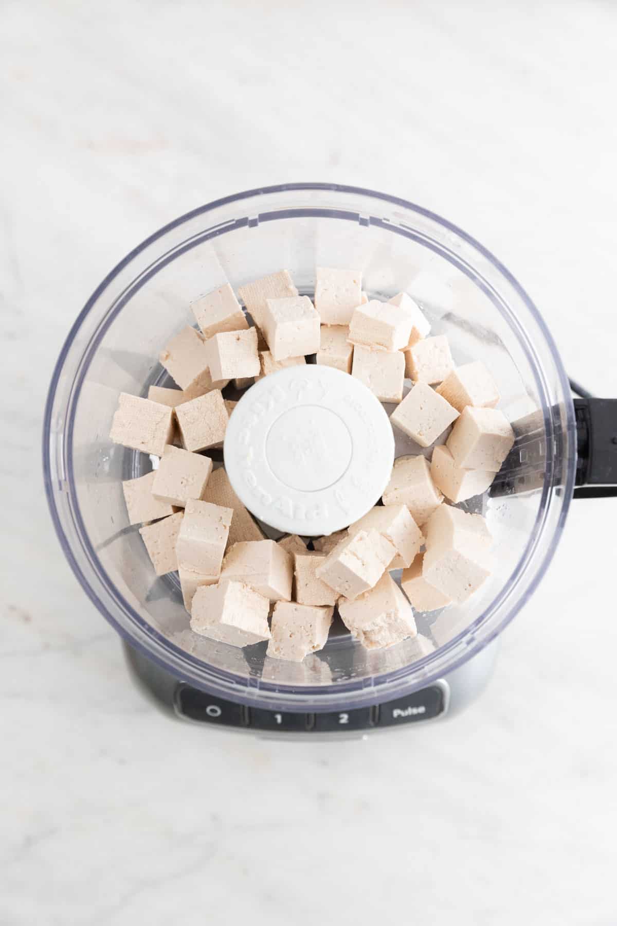 Chopped tofu in a food processor.